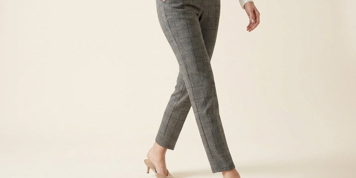 Cropped view of a woman wearing grey Glen plaid slim-leg ankle trousers with side pockets and pointed-toe kitten heel mules.