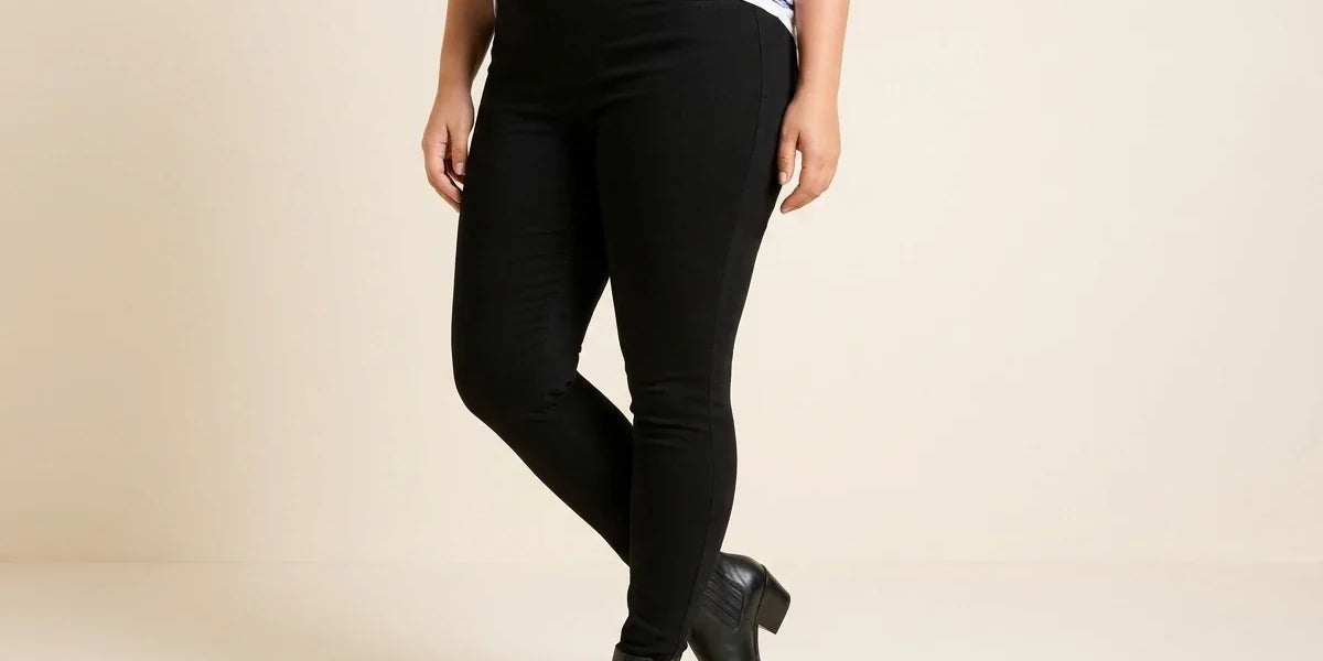Cropped view of a woman wearing high-waisted solid black stretch leggings paired with black pointed-toe leather ankle boots and a striped top.