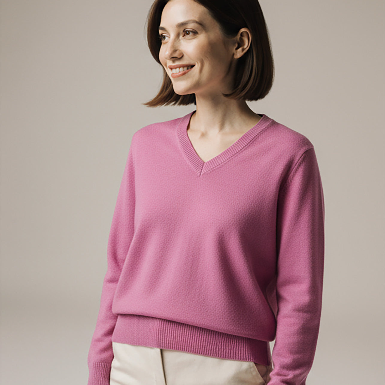 Woman wearing a pink sweater against a plain background