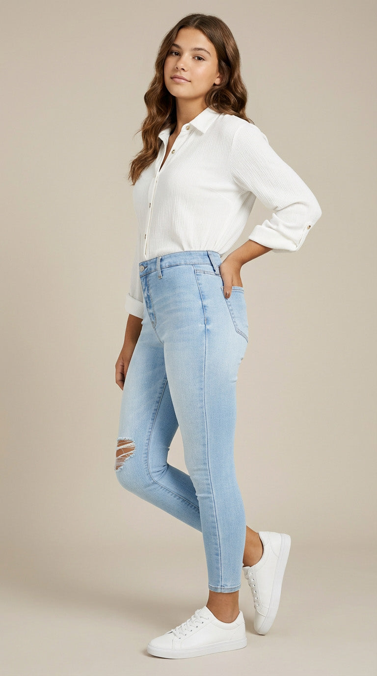 Woman wearing a white shirt and light blue jeans on a beige background