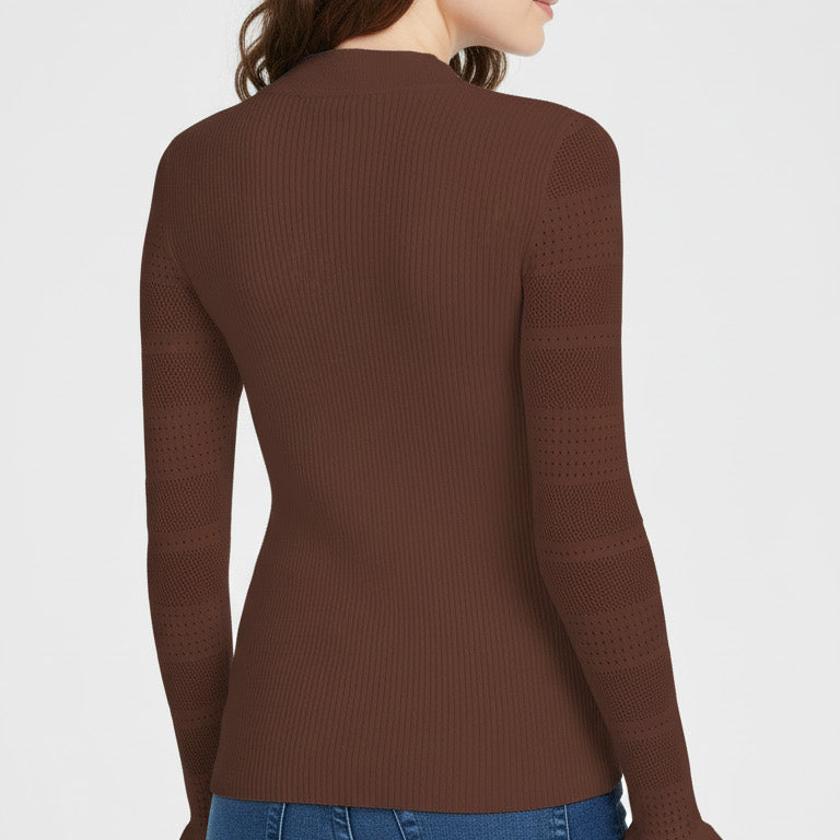 Woman wearing a brown long-sleeve top and blue jeans on a white background