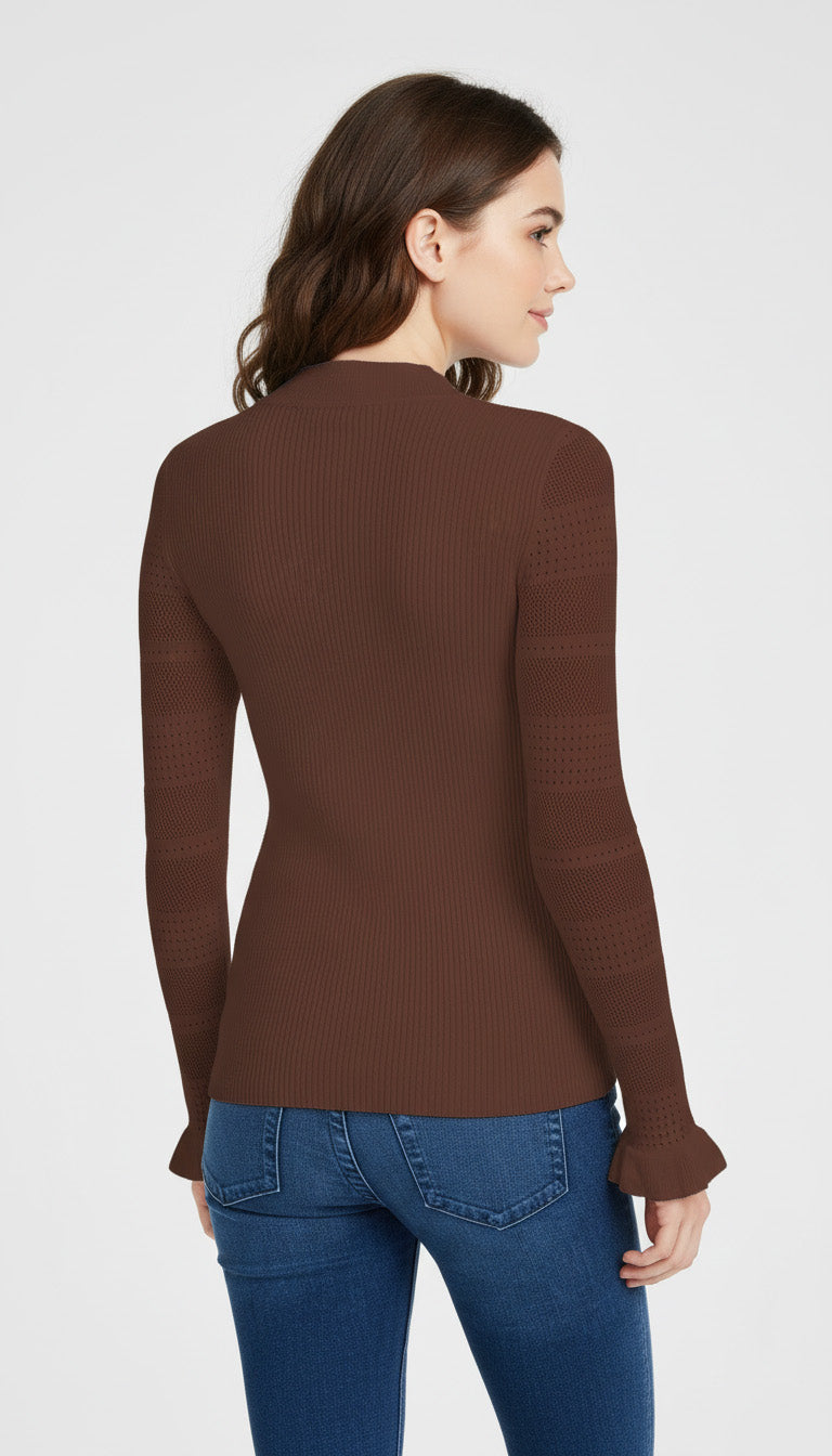 Woman wearing a brown long-sleeve top and blue jeans on a white background