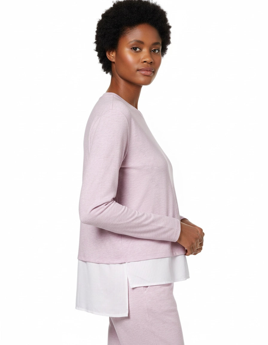 Woman wearing a light pink outfit with a white skirt on a white background