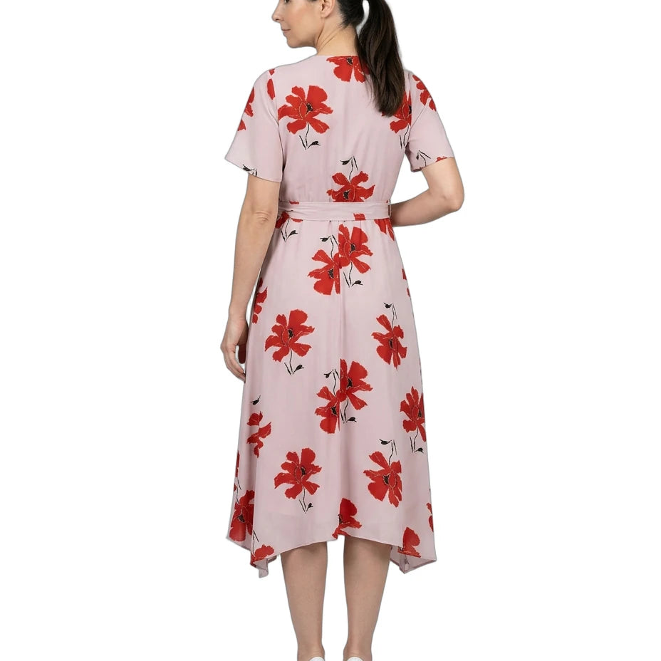 Woman wearing a pink dress with red floral pattern on a white background