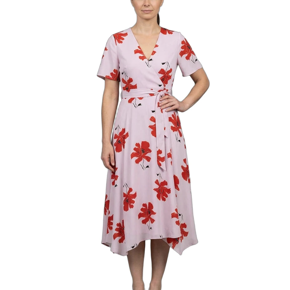 Woman wearing a pink dress with red floral pattern on a white background