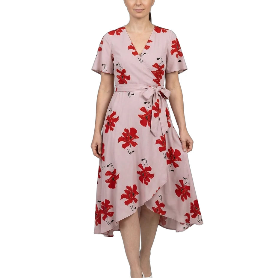 Woman wearing a pink dress with red floral pattern on a white background