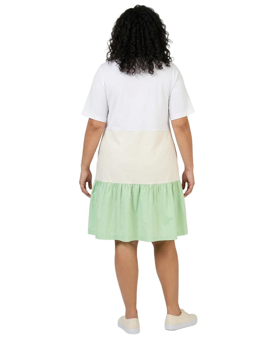 Person wearing a white top and green skirt on a white background