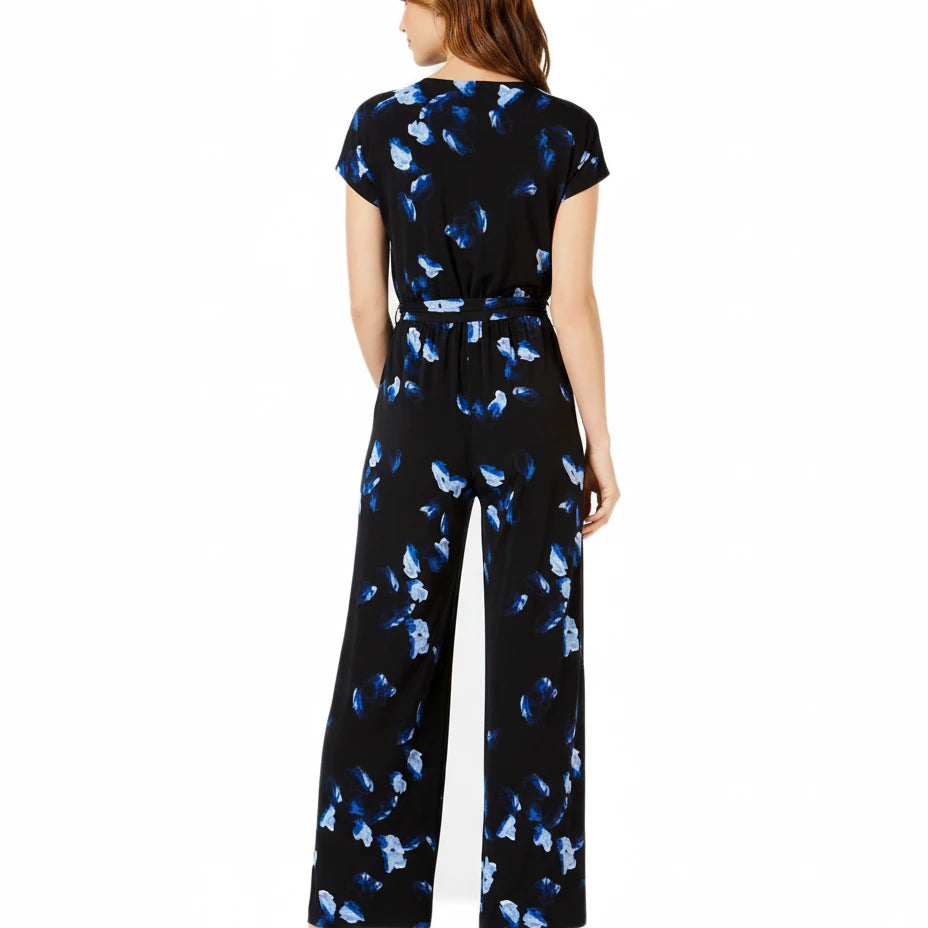 Woman wearing a black jumpsuit with blue butterfly pattern on a white background