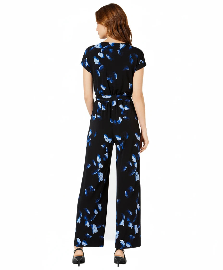 Woman wearing a black jumpsuit with blue butterfly pattern on a white background