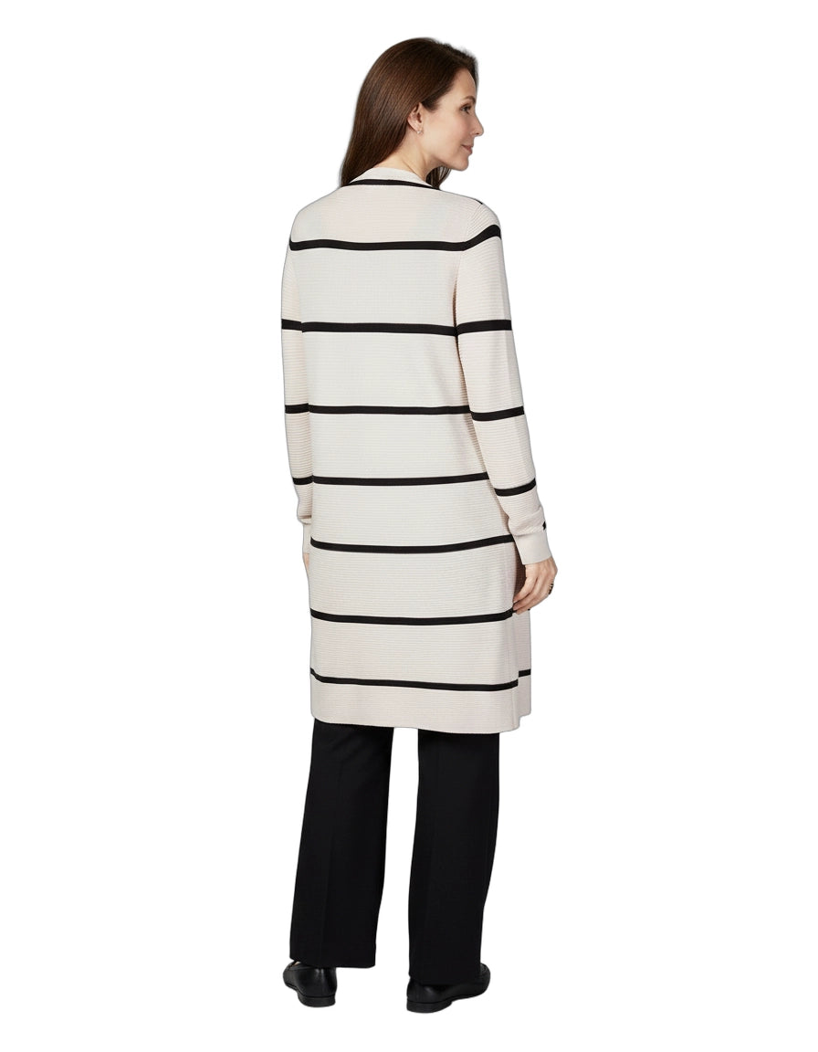 Woman wearing a long, striped sweater dress on a white background