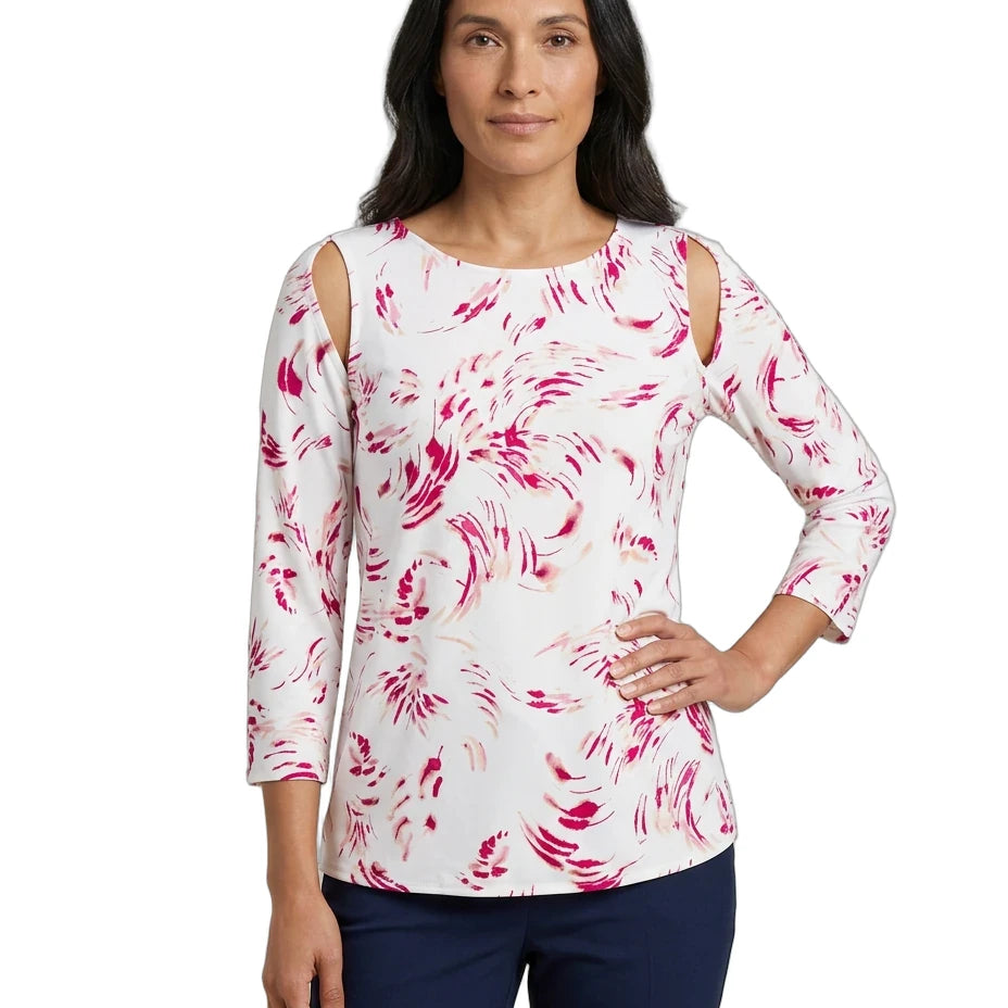 A woman modeling a white three-quarter sleeve top with pink abstract swirl patterns and cold-shoulder cutouts, paired with navy pants, against a plain white background.