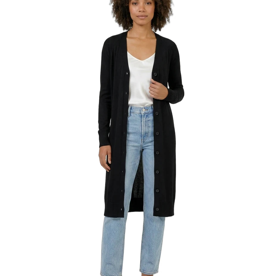 Woman wearing a black cardigan, white shirt, and blue jeans on a white background