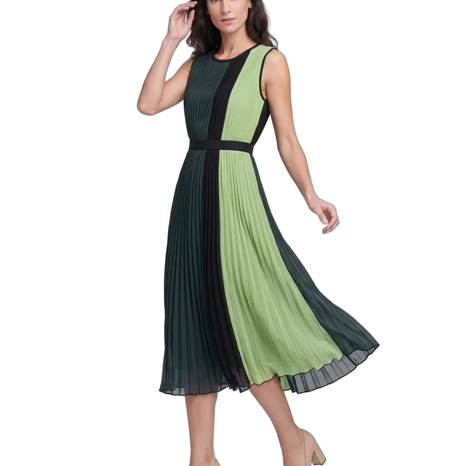 A woman modeling a sleeveless pleated midi dress with a color-blocked design in dark green and light green, featuring a black waistband and black side panels, paired with beige high heels against a white background.