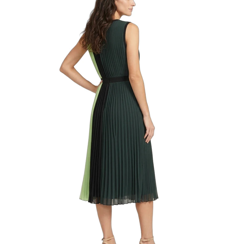 A woman modeling a sleeveless pleated midi dress from the back, featuring a dark green body with a light green side panel and a black waistband, paired with beige heeled sandals against a white background.