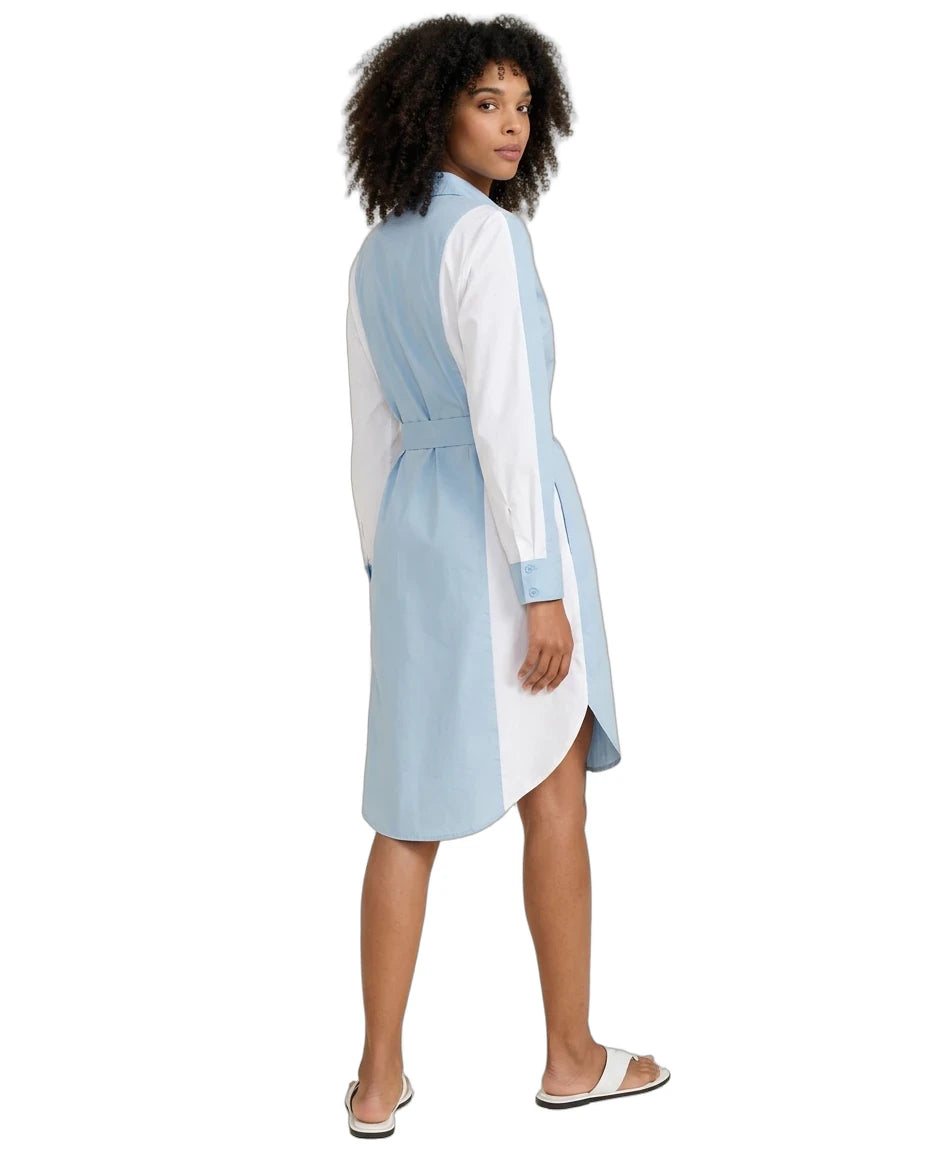 A woman modeling a light blue and white color-blocked shirt dress, shown from a side-back angle against a plain white background.