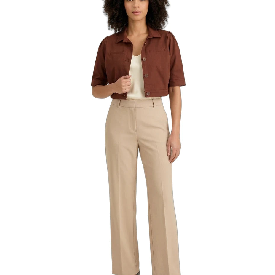 A woman modeling a brown short-sleeve cropped button-up shirt, beige wide-leg trousers, a cream top, and black heels against a plain white background.