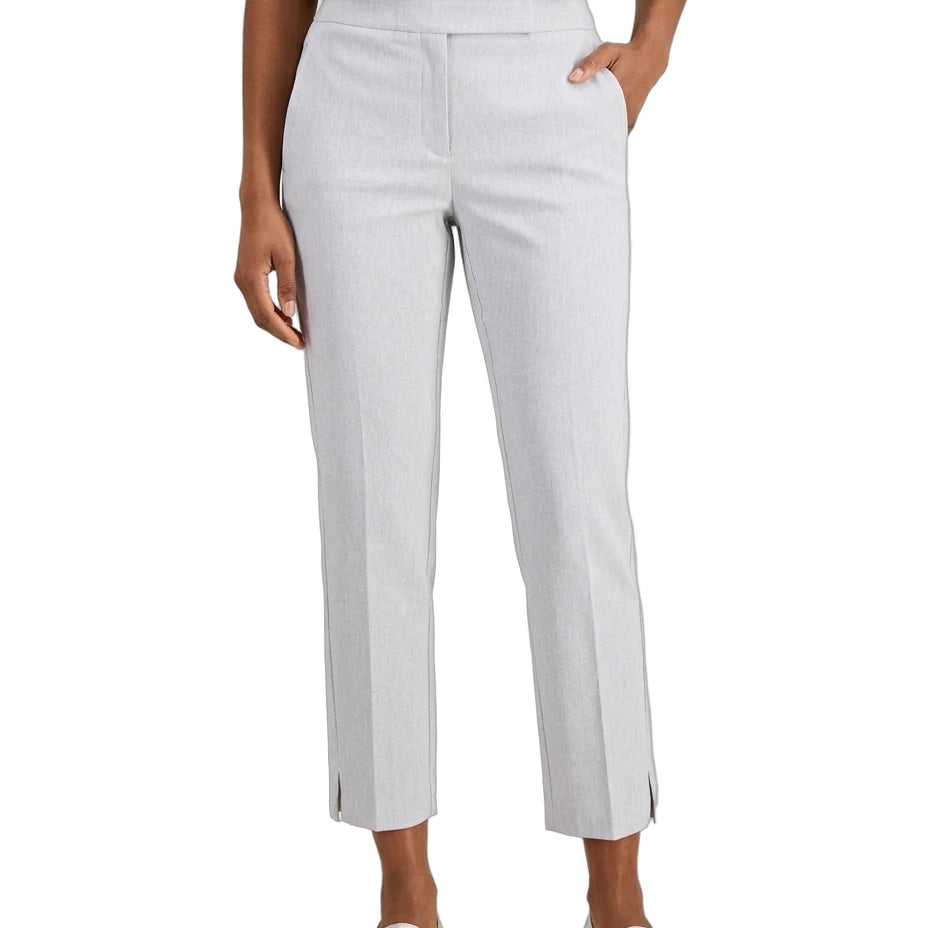 A model wearing light gray cropped trousers with side slits, paired with a navy top and metallic silver loafers, shown against a plain white background.