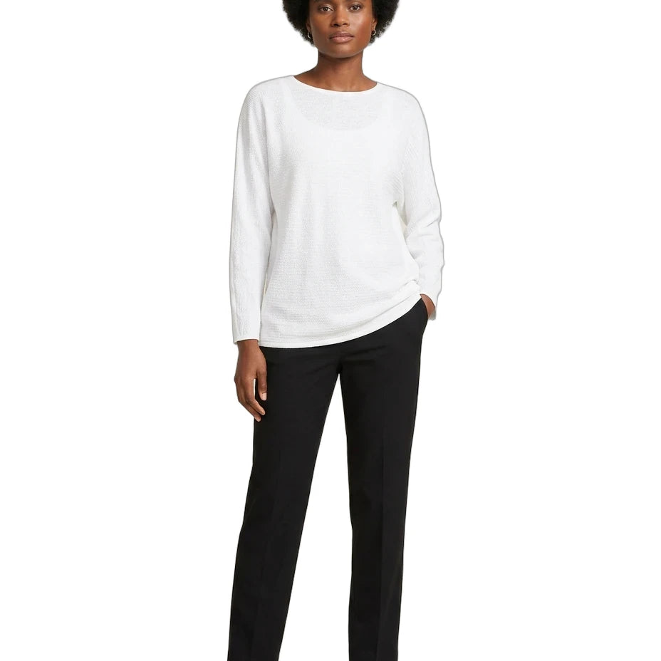 Person wearing a white sweater and black pants on a white background