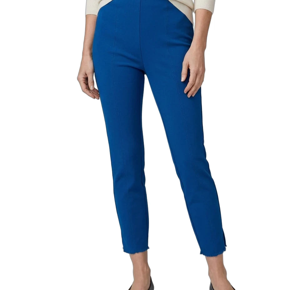 A model wearing bright royal blue cropped pants, paired with a cream long-sleeve top and black flats, shown against a plain white background.