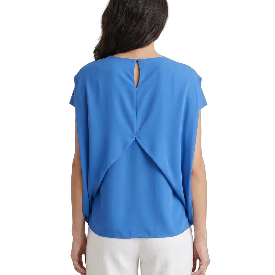 Woman wearing a blue top with a cut-out back design on a white background