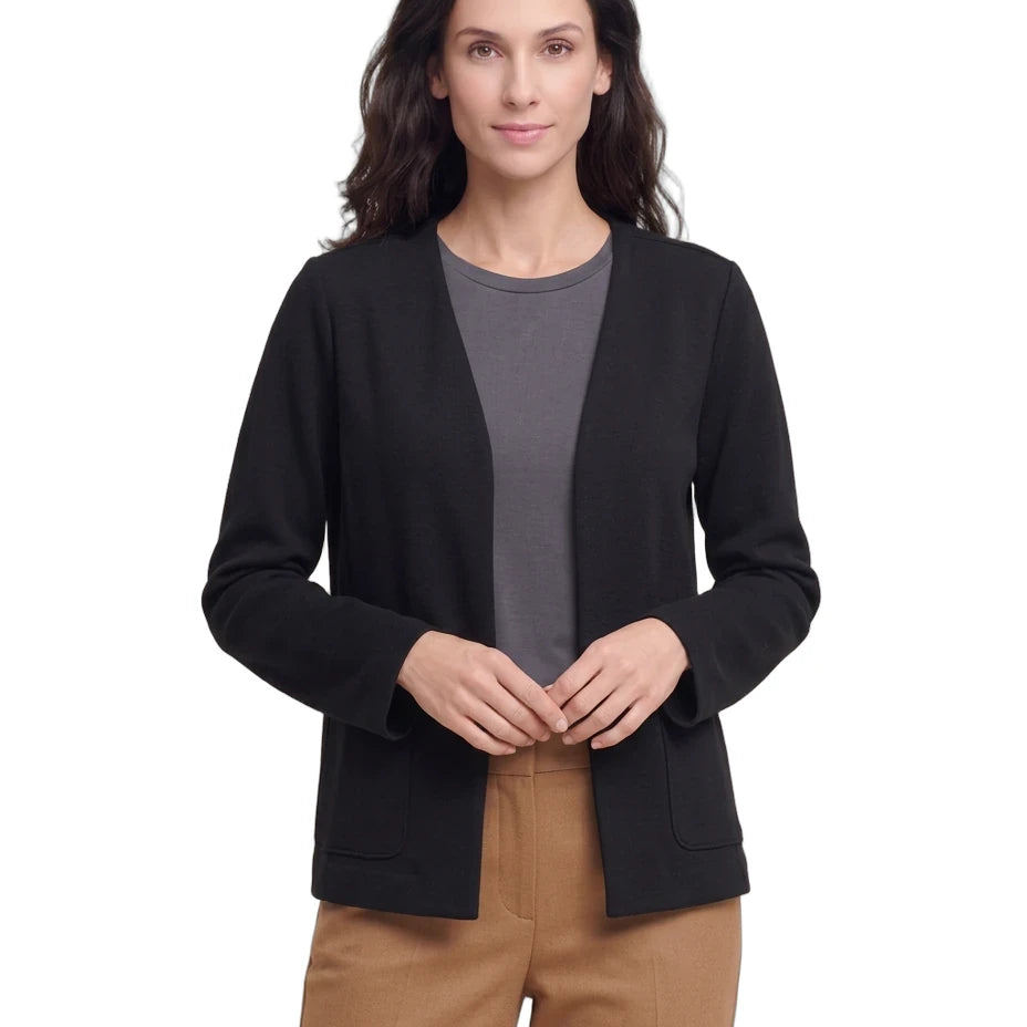 A woman modeling a black open-front cardigan over a dark gray crewneck top and tan pants, photographed against a plain white studio background.