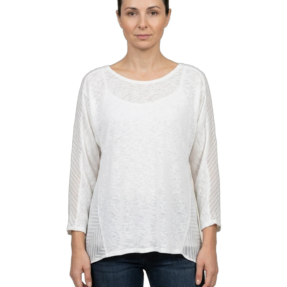Woman wearing a white long-sleeve top and dark jeans on a white background