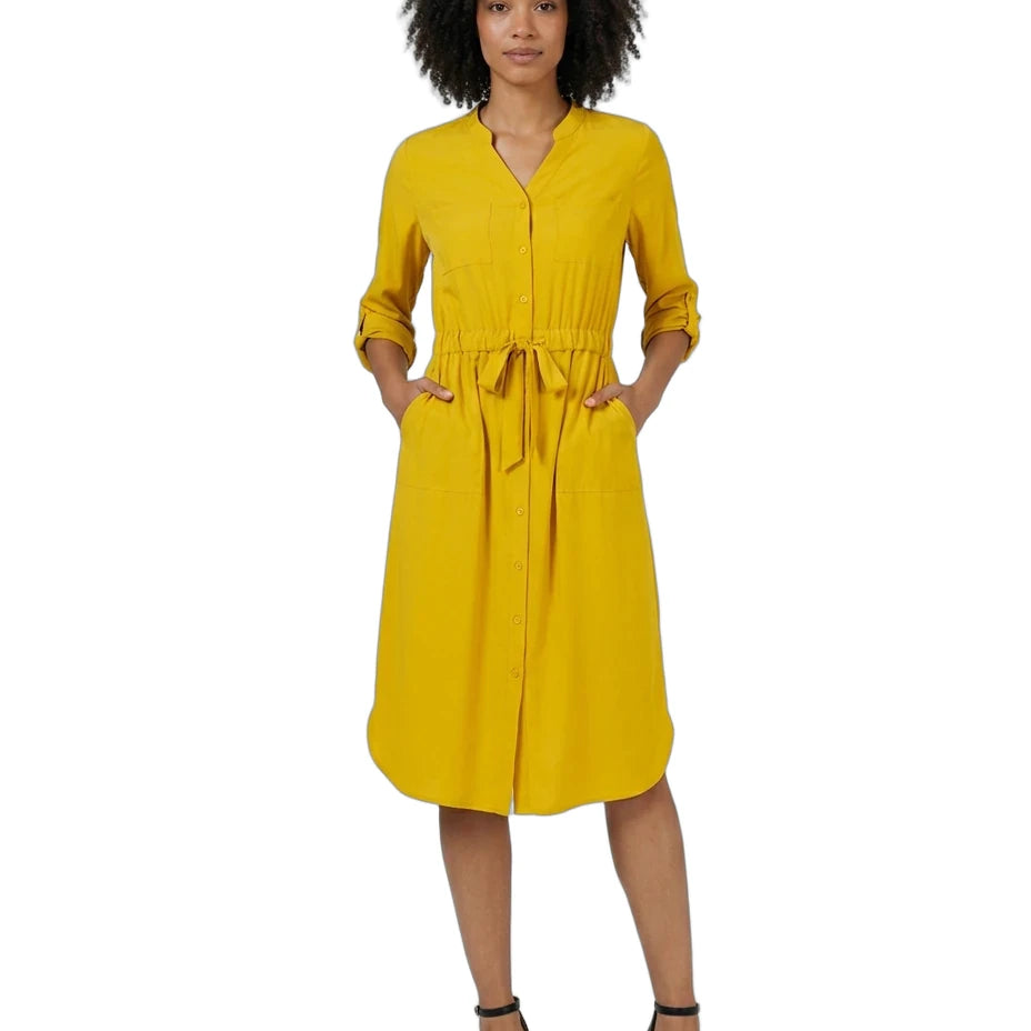 A woman modeling a mustard yellow midi shirt dress with three-quarter sleeves, a button-up front, side pockets, and a self-tie waist belt, paired with black strappy heels against a plain white background.