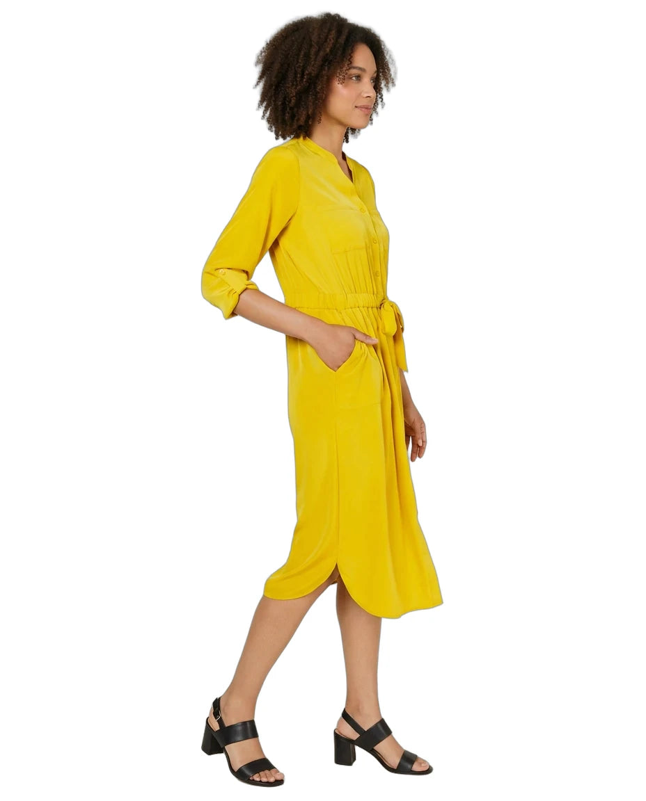 A woman modeling a bright yellow midi dress with three-quarter sleeves, a tie waist, and side pockets, paired with black strappy sandals against a plain white background.