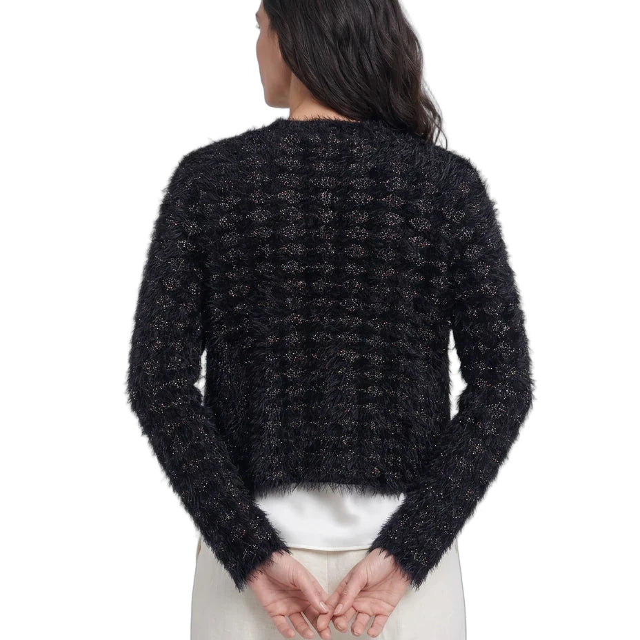 Person wearing a black textured sweater on a white background