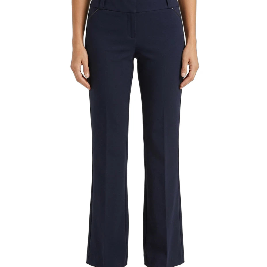 A model wearing a pair of navy blue high-waisted, straight-leg pants with a cream top and brown shoes, shown from the waist down on a white background.