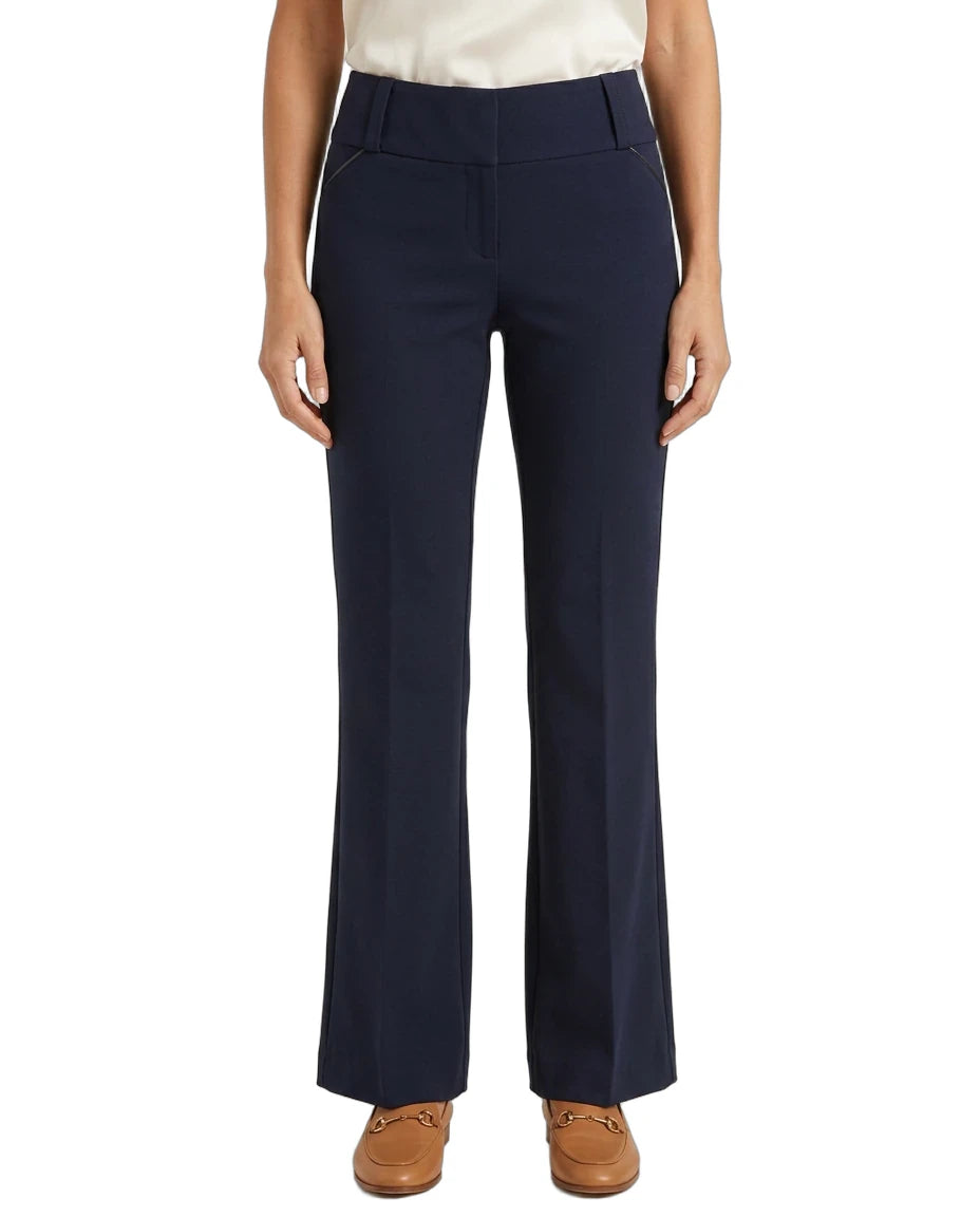 A model wearing a pair of navy blue high-waisted, straight-leg pants with a cream top and brown shoes, shown from the waist down on a white background.