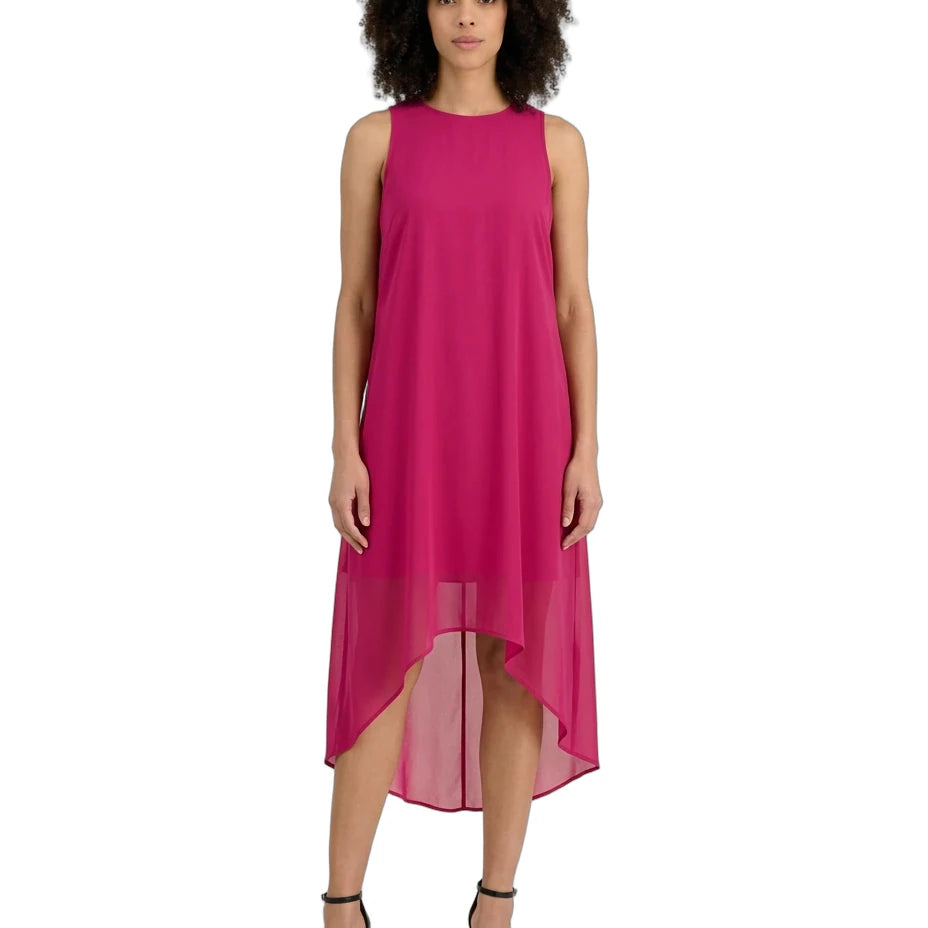 A woman modeling a sleeveless high-low midi dress in a vibrant magenta pink, paired with black strappy high-heeled sandals, against a plain white background.