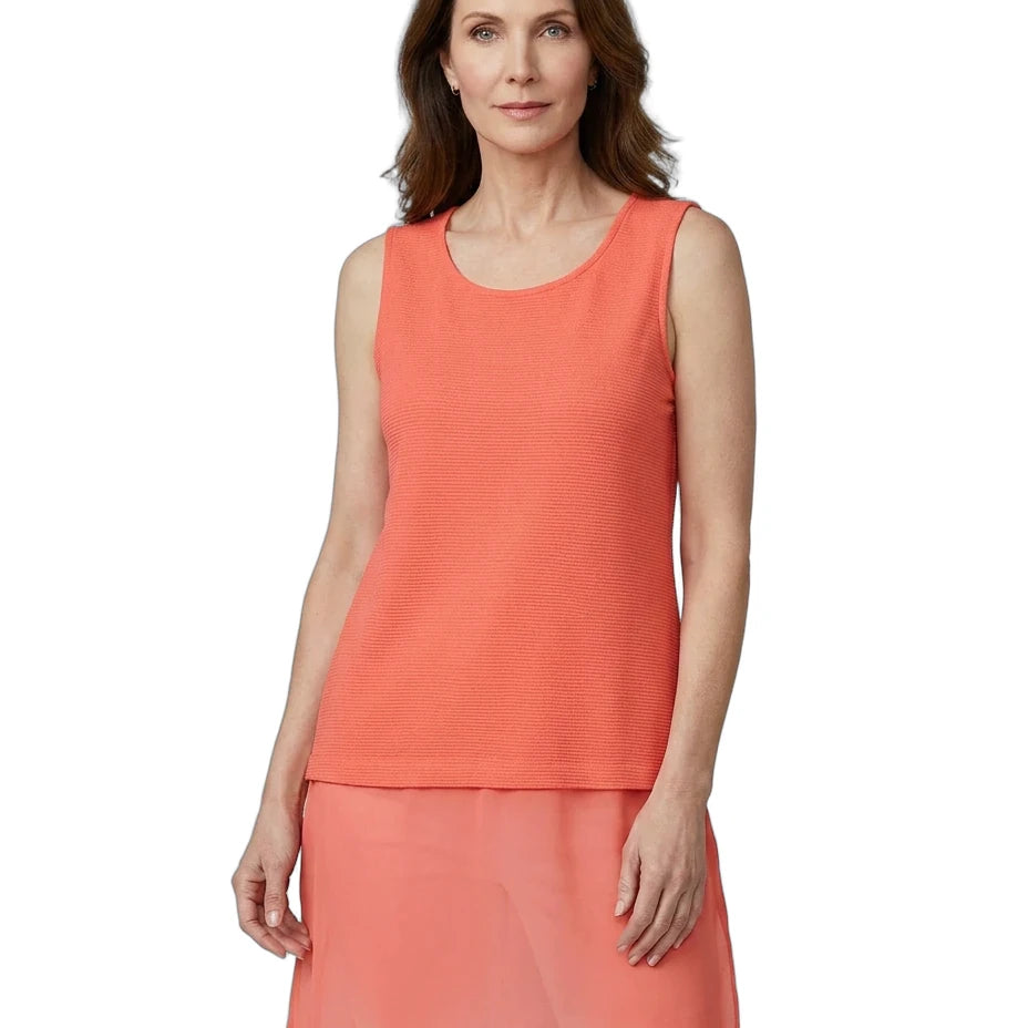 Woman wearing a coral sleeveless top with a white background