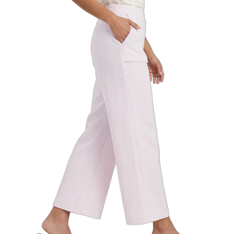 A model wearing light pink cropped wide-leg pants with side pockets, paired with a white top and clear block-heel mule sandals, shown against a plain white background.