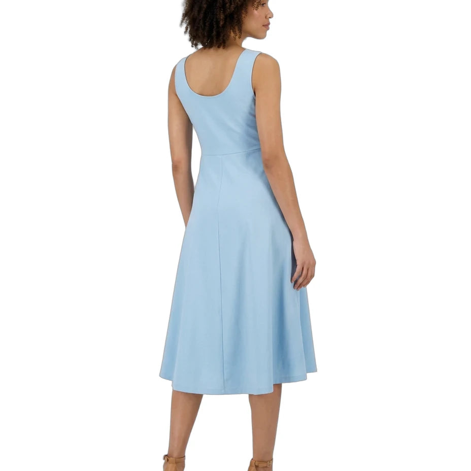 A woman shown from the back wearing a sleeveless light blue midi dress and tan ankle-strap heels against a plain white background.