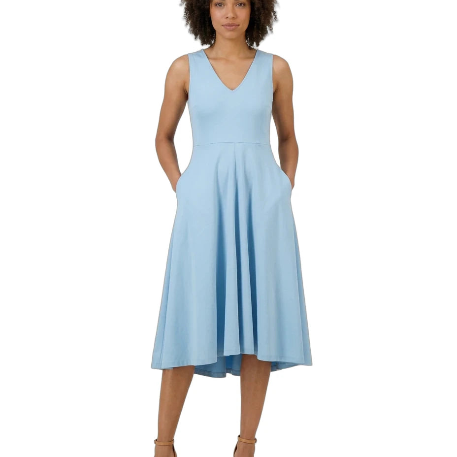 A woman modeling a sleeveless light blue midi dress with a V-neckline, side pockets, and a flared skirt, paired with tan heeled sandals against a plain white background.