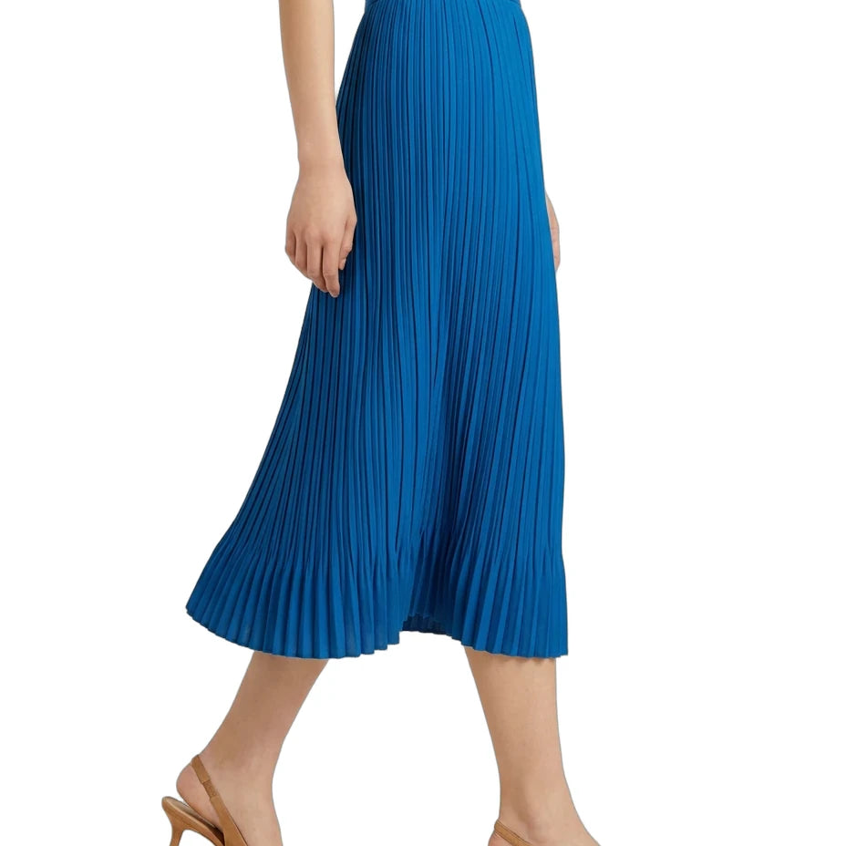 A model wearing a bright blue pleated midi skirt with a white top and tan slingback heels, shown from the waist down against a plain white background.
