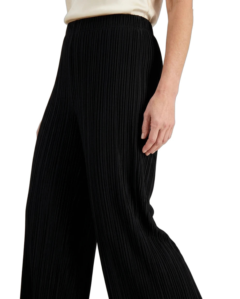 Black pleated wide-leg trousers shown on a model from the waist down, paired with a cream satin top against a plain white background.