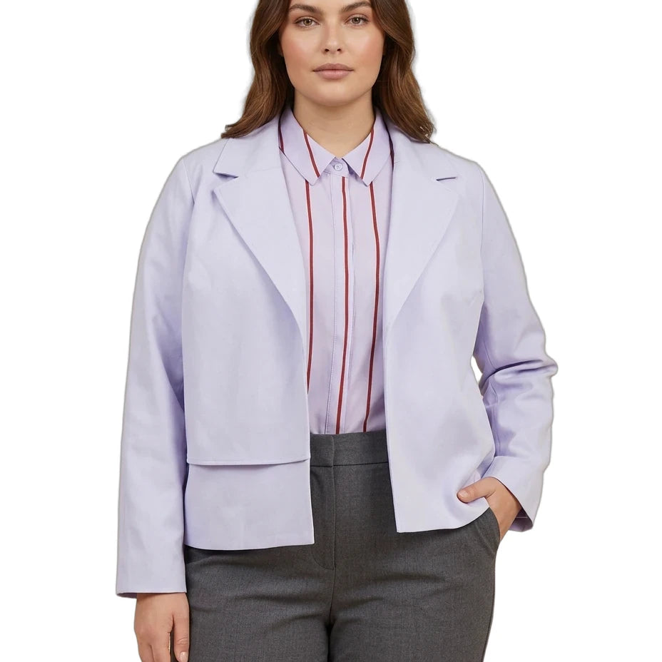 A woman modeling a light lavender cropped blazer over a pink striped button-down shirt and gray trousers, shot against a plain white background.