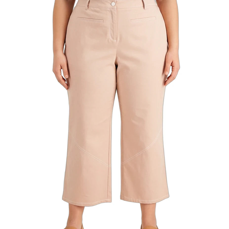A model wearing a pair of light beige cropped wide-leg pants, paired with a navy top and tan flat shoes, shown against a plain white background.