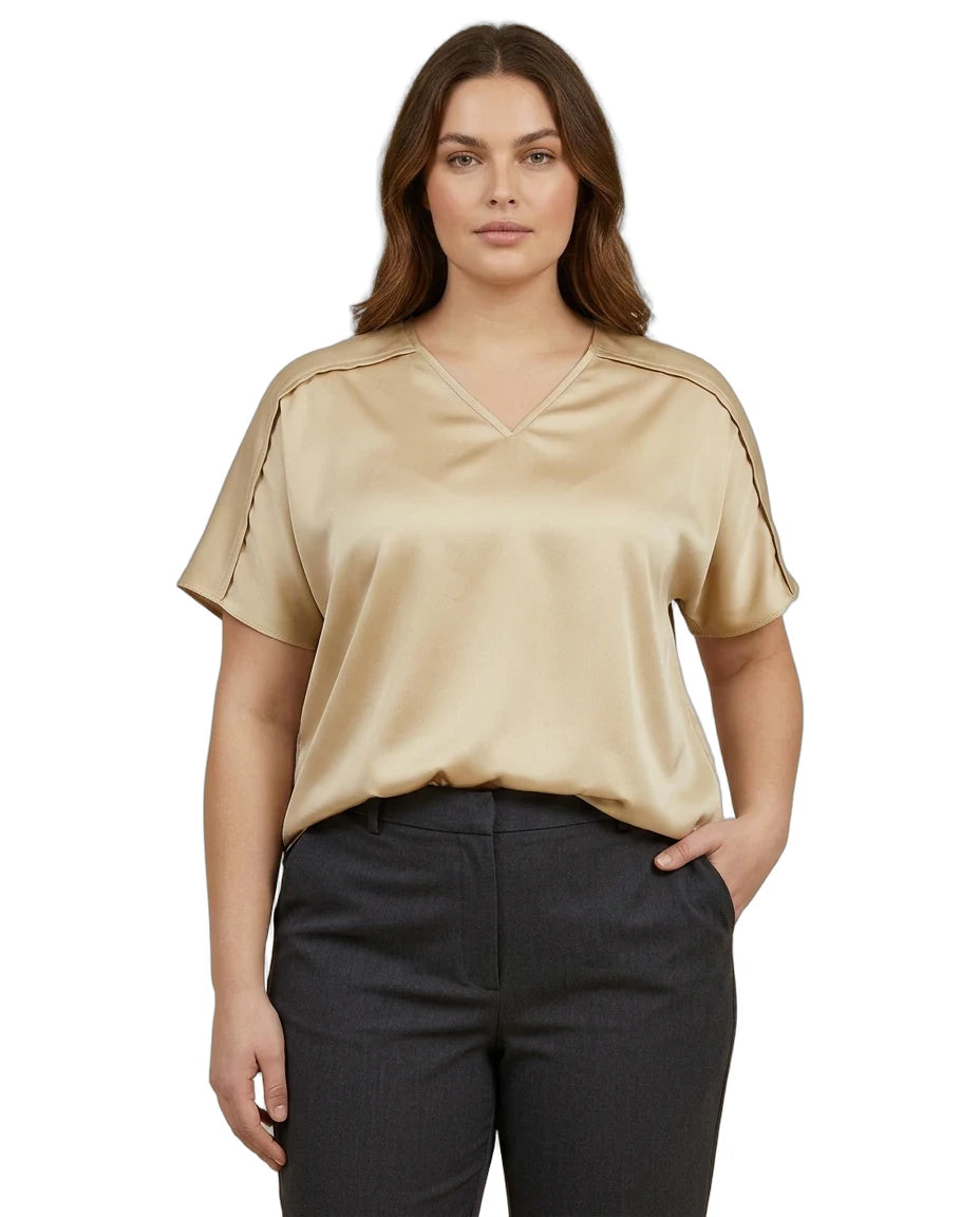 Woman wearing a beige blouse and black pants on a white background
