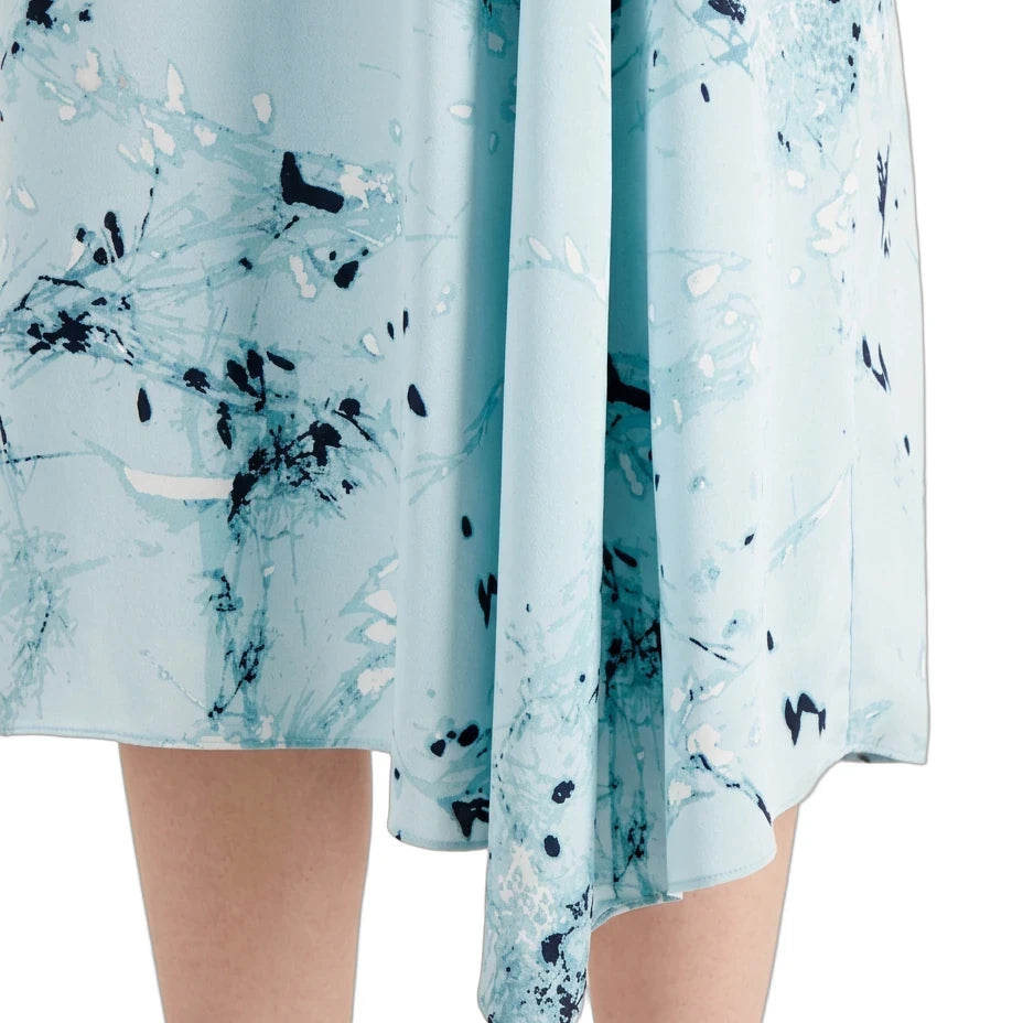 A close-up of a light blue skirt with an abstract black and white marble print, shown on a model against a white background.
