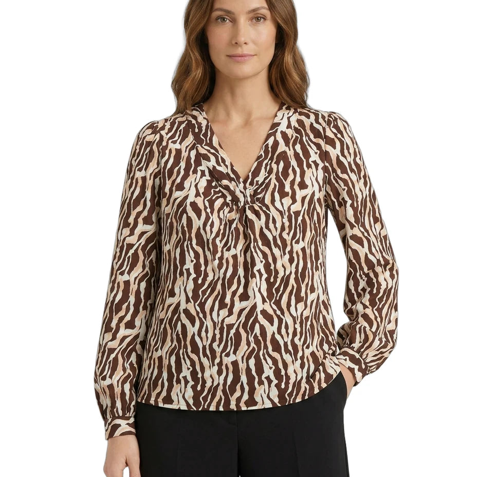 Woman wearing a brown and beige patterned blouse on a white background