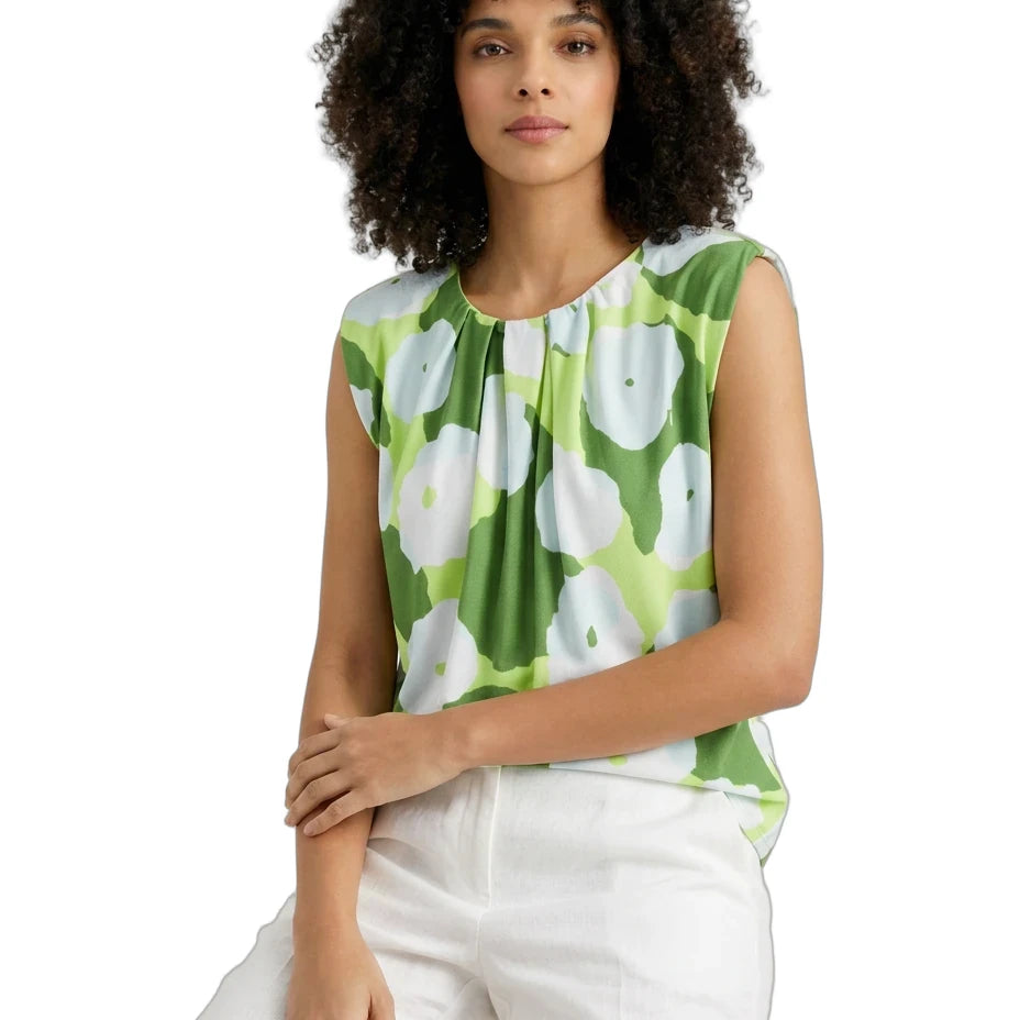 Woman wearing a green floral sleeveless top on a white background