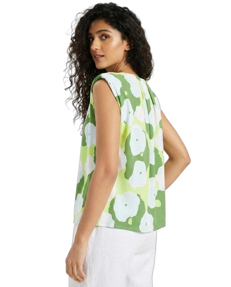 Woman wearing a green floral sleeveless top on a white background
