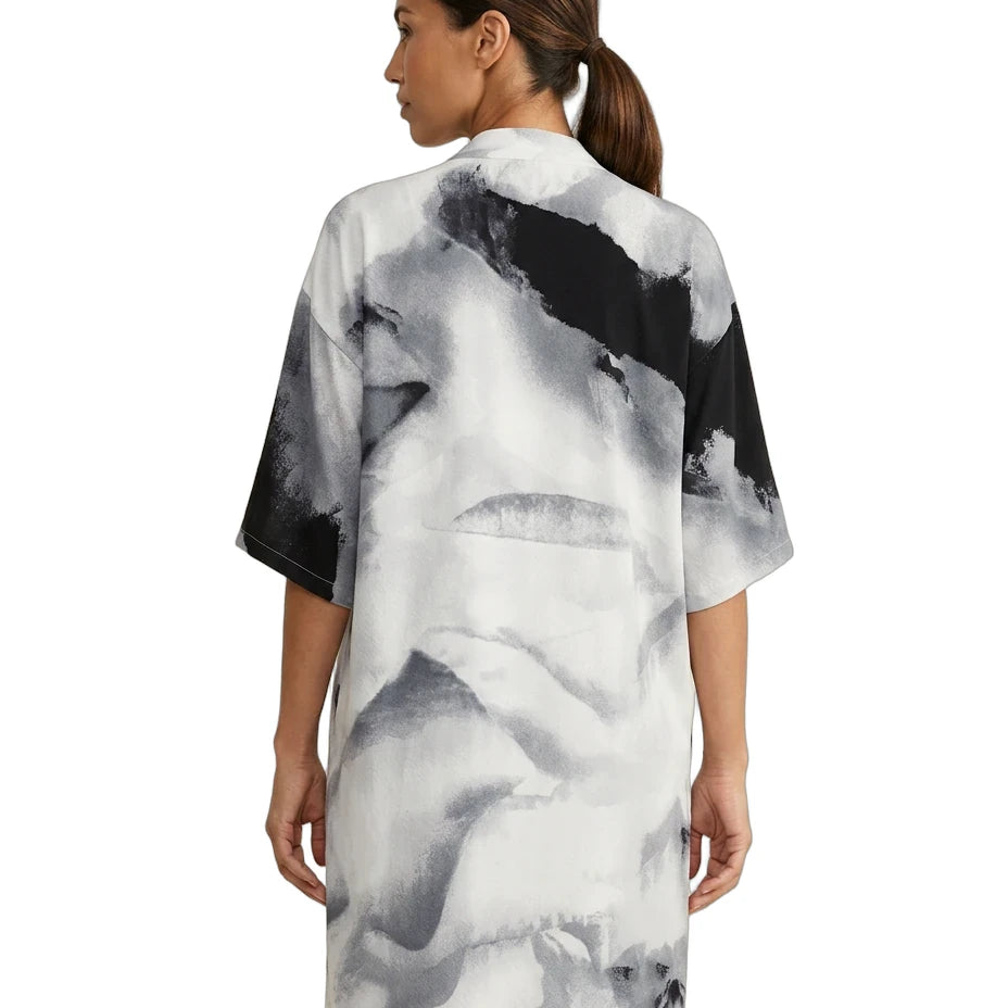 Woman wearing a black and white abstract patterned dress on a white background