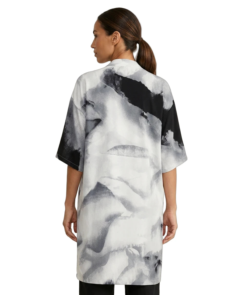Woman wearing a black and white abstract patterned dress on a white background