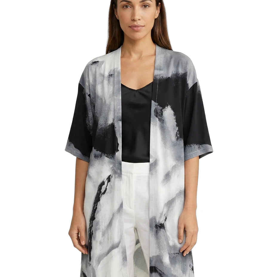 Woman wearing a black, white, and gray abstract patterned kimono-style jacket on a white background