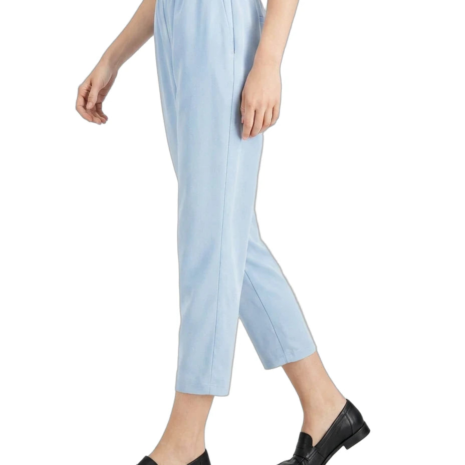 A person wearing light blue cropped trousers with an elastic waistband, paired with a light blue top and black loafers, shown against a plain white background.