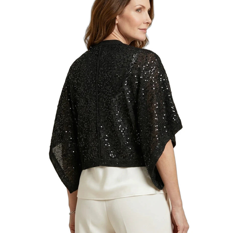 Woman wearing a black sequin top and white pants on a white background